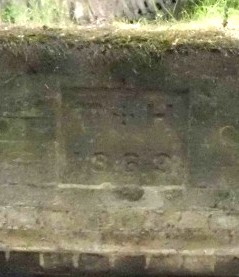 The plaque 'T H 1863' incorporated in the brick-built embankment.