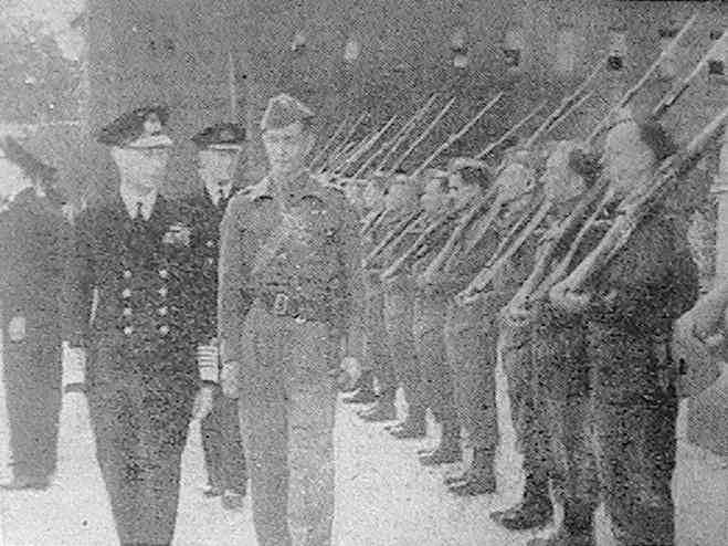 'The King inspecting the Bear Wood Home Guard on the occasion of their Majesties' visit to the Royal Merchant Navy School'